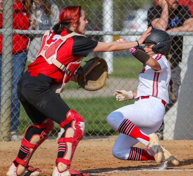 Smyrna's Savanah Arnold scores on a two-RBI hit from Lindsey Roscoe as Polytech catcher Brianna Benton waves off a throw home in Polytech's 8-3 win at Smyrna High School, Thursday, April 18, 2024. The play gave Smyrna a 2-0 lead in the third inning.