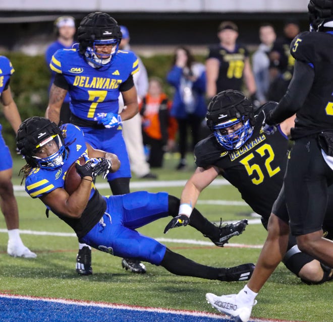 Delaware running back Quincy Watson gets in the end zone as defensive lineman Dominick Brogna knocks him off balance but too late to stop him from scoring during the Blue and White Spring Game at Delaware Stadium, Friday, April 19, 2024.