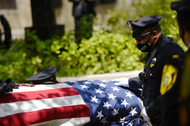 After giving a speech, an officer touches the casket of Officer Charles Edward Roberts III, outside of the Glen Ridge Municipal Complex during a memorial service in Glen Ridge on 05/14/20.