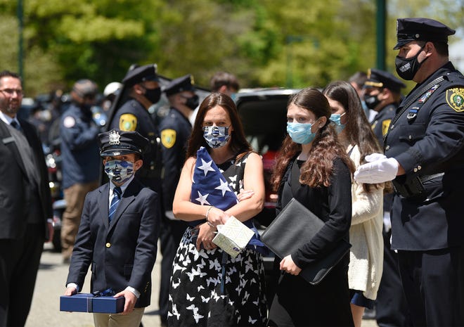 Family members of Officer Charles Edward Roberts III, (L to R) Gavin (10), wife, Alice, Natalie (12) and Shea (15) behind Natale, leave following the memorial service of Officer Charles Edward Roberts III, who died of complications related to COVID-19 on Monday, outside of the Glen Ridge Municipal Complex in Glen Ridge on 05/14/20.