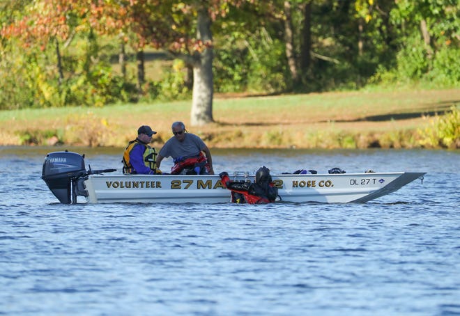 Emergency personnel search Lums Pond for two people missing after one apparently fell off a boat and another tried to rescue them shortly before noon Thursday, Oct. 15, 2020.