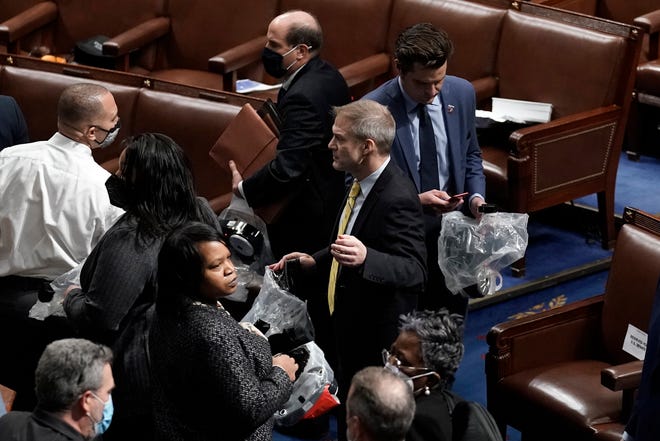House of Representatives members leave the floor of the House chamber as protesters try to break into the chamber at the U.S. Capitol on Wednesday, Jan. 6, 2021, in Washington. Rep. Jim Jordan, R-Ohio, is at center. (AP Photo/J. Scott Applewhite) ORG XMIT: DCSA320