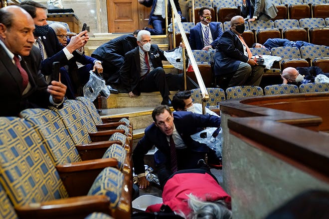 People shelter in the House gallery as protesters try to break into the House Chamber at the U.S. Capitol on Wednesday, Jan. 6, 2021, in Washington. (AP Photo/Andrew Harnik) ORG XMIT: DCAH324
