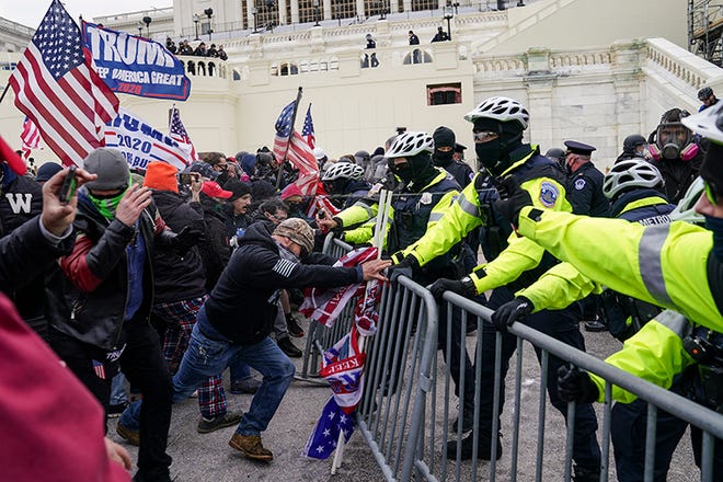 Trump supporters try to break through a police barrier, Wednesday, Jan. 6, 2021, at the Capitol in Washington. As Congress prepares to affirm President-elect Joe Biden's victory, thousands of people have gathered to show their support for President Donald Trump and his claims of election fraud.(AP Photo/John Minchillo) ORG XMIT: DCJM233