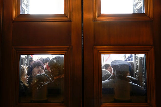 U.S. Capitol Police try to hold back protesters outside the east doors to the House side of the U.S. Capitol, Wednesday, Jan 6, 2021. (AP Photo/Andrew Harnik) ORG XMIT: DCAH314