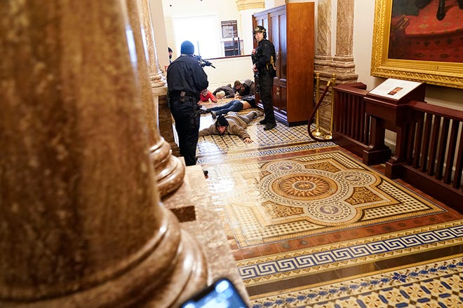 U.S. Capitol Police hold rioters at gunpoint near the House Chamber inside the U.S. Capitol on Wednesday, Jan. 6, 2021, in Washington.