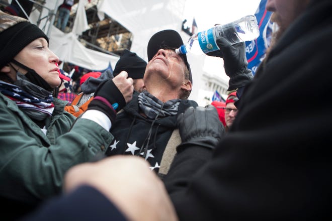 Jan 6, 2021; Washington, DC, USA; A Trump supporter receives aid after tear gas was deployed at rioters storming the U.S. Capitol Wednesday afternoon as lawmakers inside debated the certification of the presidential election.  Mandatory Credit: Jerry Habraken-USA TODAY