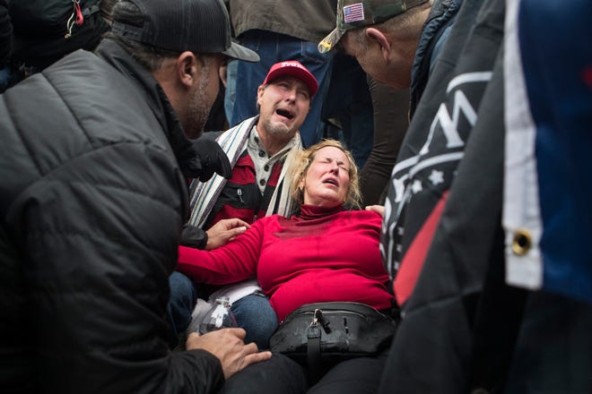 Trump supporters receive aid after being sprayed with tear gas after storming the U.S. Capitol Wednesday afternoon as lawmakers inside debated the certification of the presidential election.