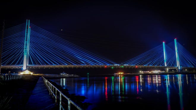 The Charles W. Cullen Bridge is lit blue at nighttime.